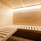 Interior view of natural wood sauna with two bench levels, horizontal wood paneling on walls and ceiling, and skylight openin