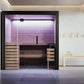 Almost Heaven Nordik indoor sauna with cedar wood interior, purple LED lighting, glass doors, and black frame in modern spa s
