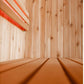 Interior view of wooden sauna with light wood walls and benches, red neon accent lighting in upper left corner