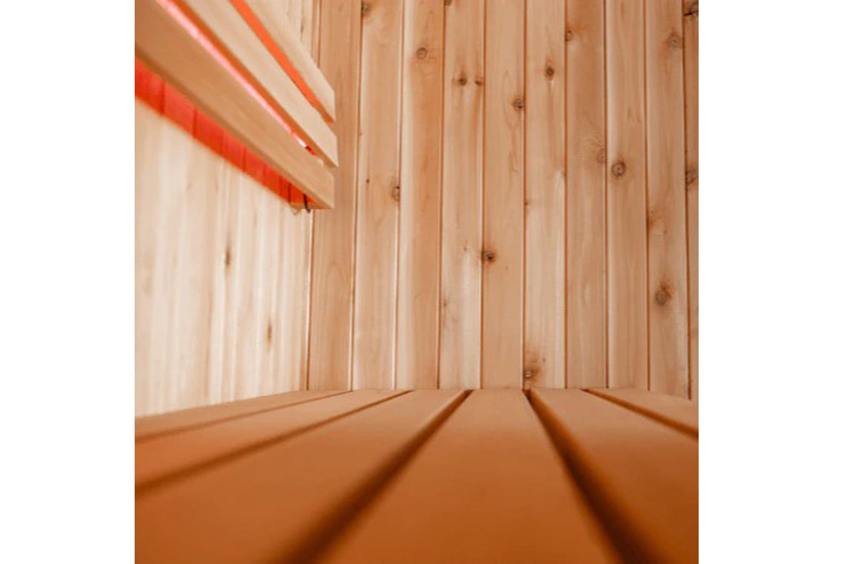 Interior view of wooden sauna with light wood walls and benches, red neon accent lighting in upper left corner