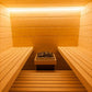 Interior of wooden sauna with benches on both sides, heated rocks, and overhead lighting