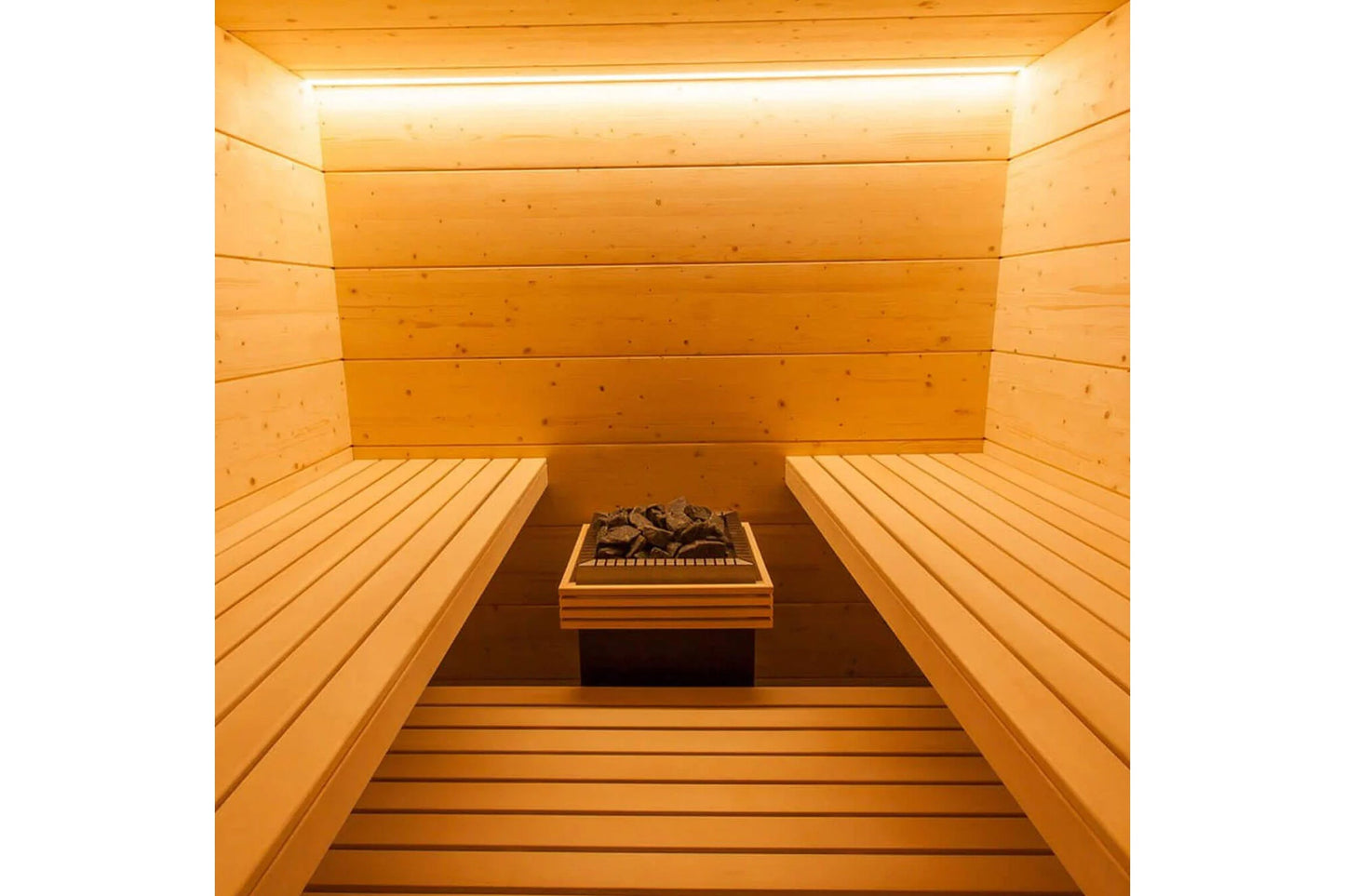 Interior of wooden sauna with benches on both sides, heated rocks, and overhead lighting