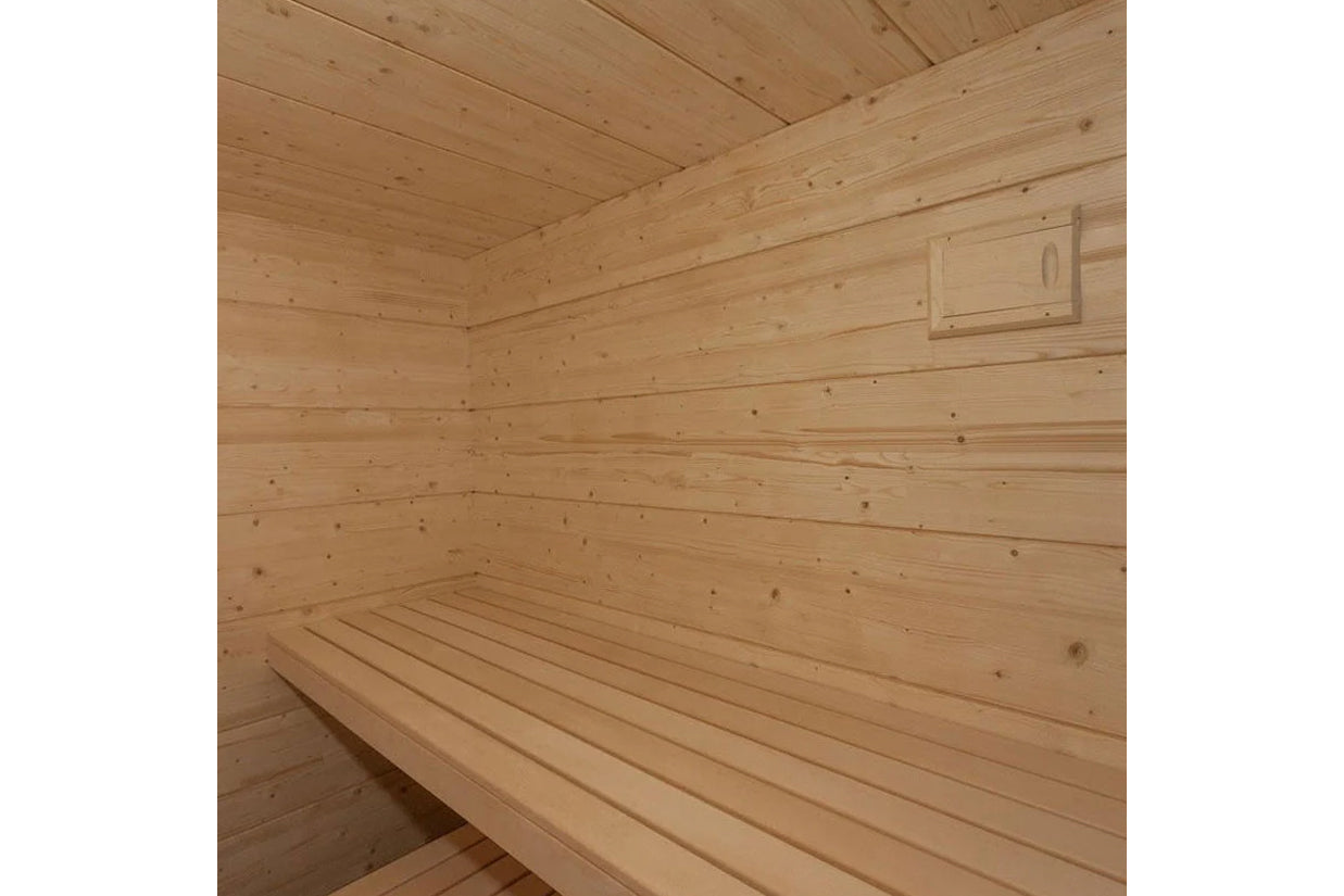 Interior view of wooden sauna with light pine walls, bench seating, and vented ceiling