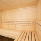 Interior view of light wood sauna with bench seating, backrest, and wooden ceiling