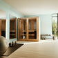 Almost Heaven Rainelle hybrid sauna with glass double doors and wood frame in mint green room with fitness equipment