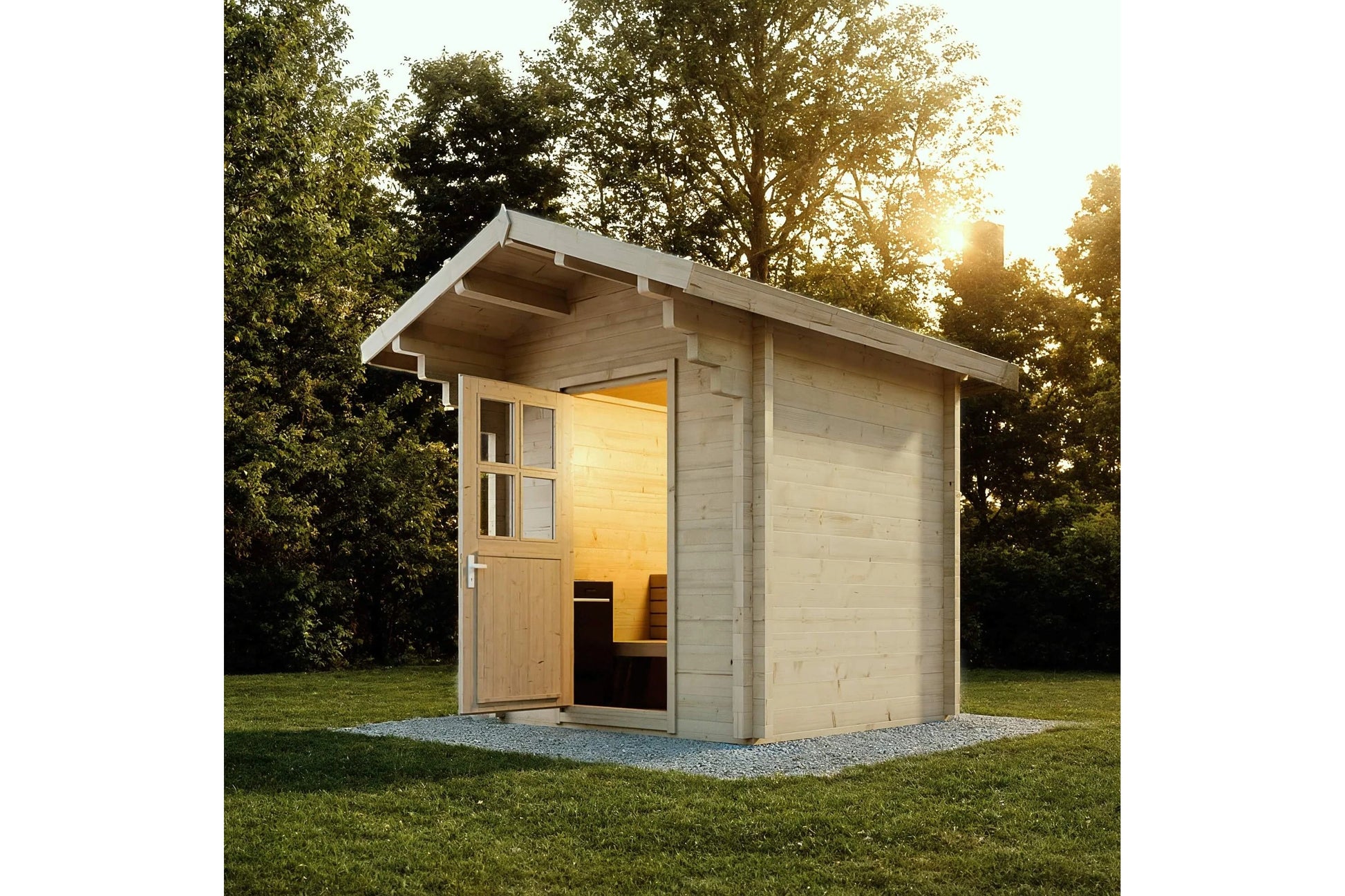 Almost Heaven Saddle Mountain outdoor sauna with light wood construction, open door showing illuminated interior, situated on