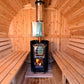 Almost Heaven Seneca barrel sauna interior with wood benches, black wood-burning stove with active fire, and metal chimney pi