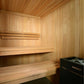 Interior view of wooden sauna with light wood walls, ceiling, tiered benches, and black Harvia heater unit in corner