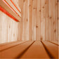 Interior view of wooden sauna with light wood paneling and red towel on upper shelf