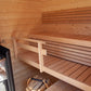 Interior view of wooden sauna cabin with two-tiered benches, Harvia stove with black stones, and light pine construction