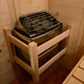 Harvia sauna heater with black metal grate basket filled with stones, mounted inside wooden sauna interior