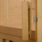 Natural wood sauna door with rectangular wooden handle and silver metal latch on pine frame