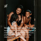 Woman and two children sitting together in wooden barrel sauna, smiling, against dark interior background