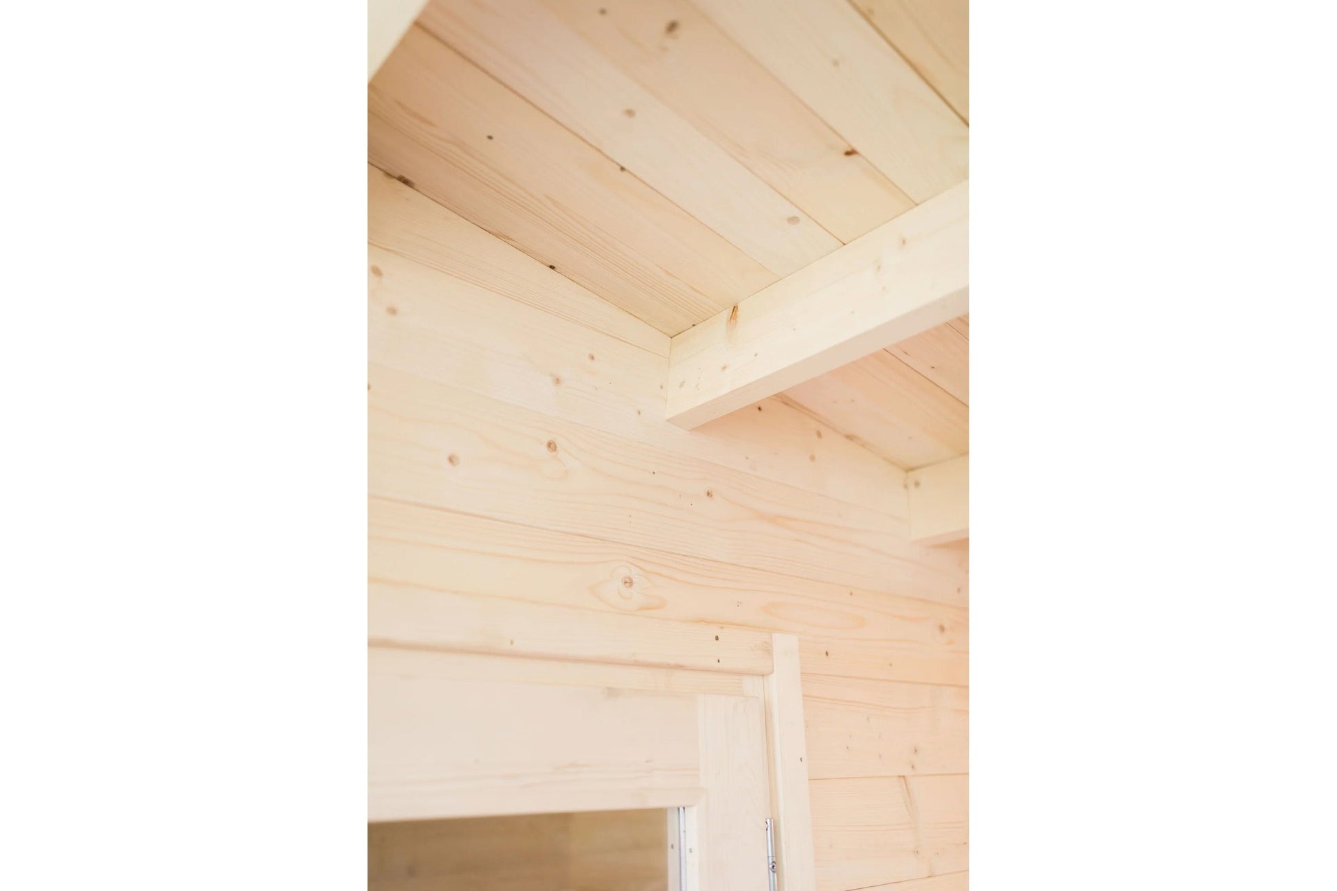 Interior view of wooden sauna ceiling and walls with exposed pine beams and horizontal wood paneling