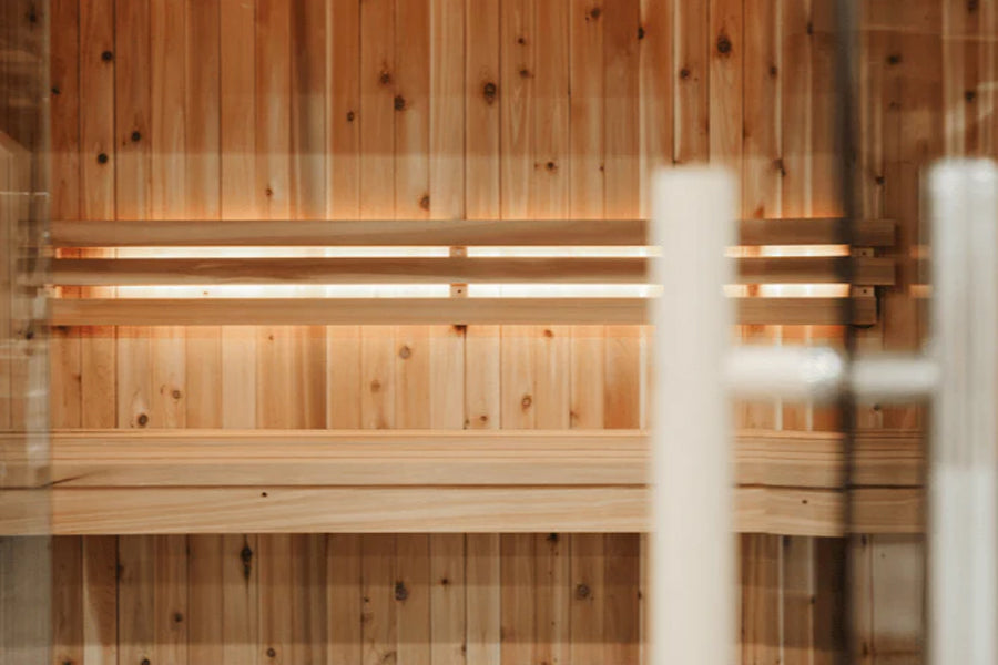 Almost Heaven Titan 6-person indoor sauna with natural wood cedar interior, wooden benches, and ambient lighting