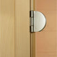 Stainless steel hinge with round chrome handle mounted on light wood door panel