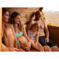 Family of four relaxing inside wooden barrel sauna with canopy, scenic landscape view visible through window