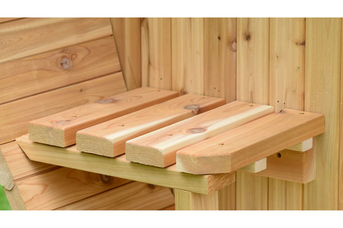 Natural wood bench seating with four rounded cedar logs inside wooden sauna, flat lay view