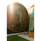 Watoga 4-person barrel sauna with dark wood exterior, glass door, and metal bands, positioned in outdoor garden setting