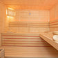 Interior view of light wood sauna with tiered benches, red accent stripe, wooden bucket, ladle, and window with warm lighting