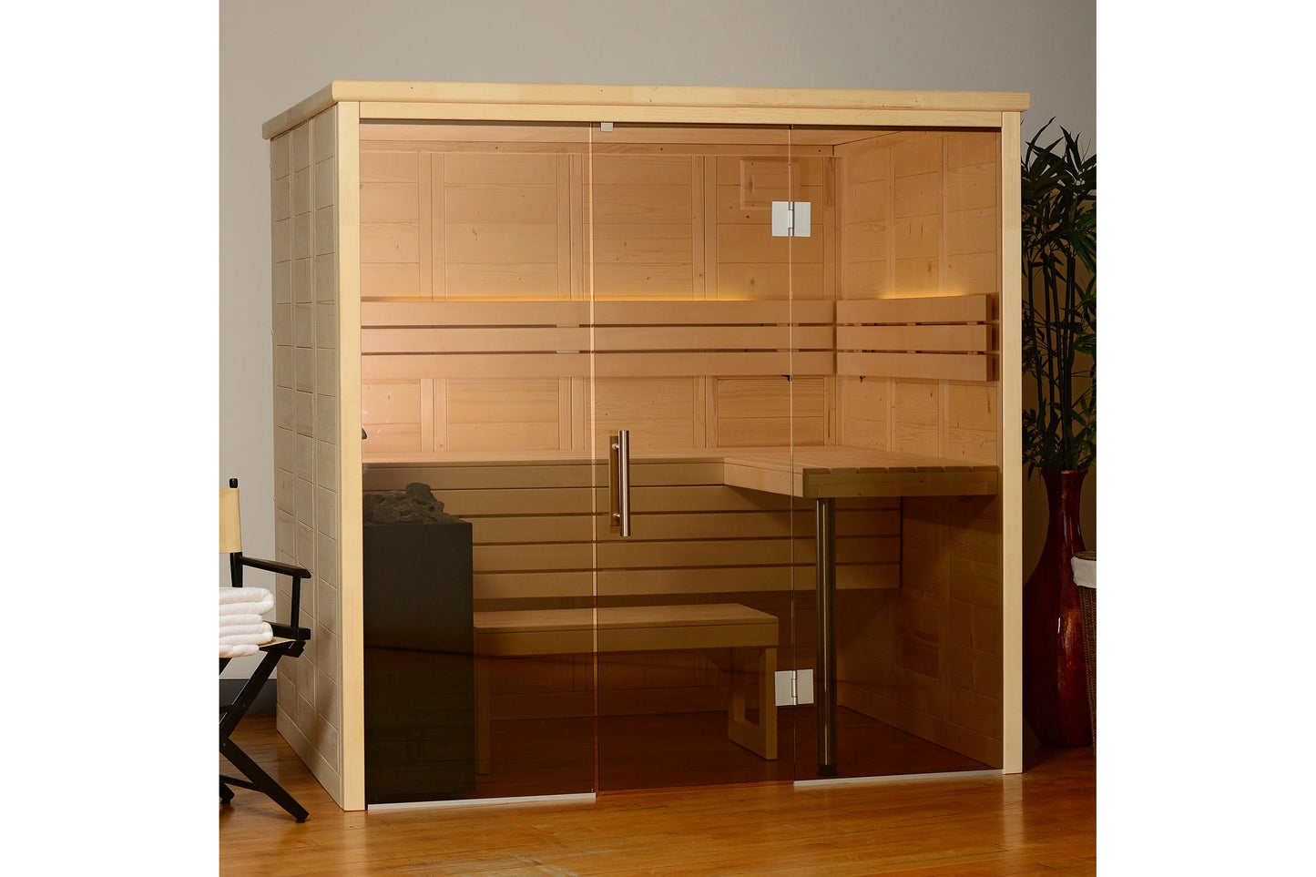 Cedar wood indoor sauna with glass door and metal handles, showing wooden benches inside, on wooden floor