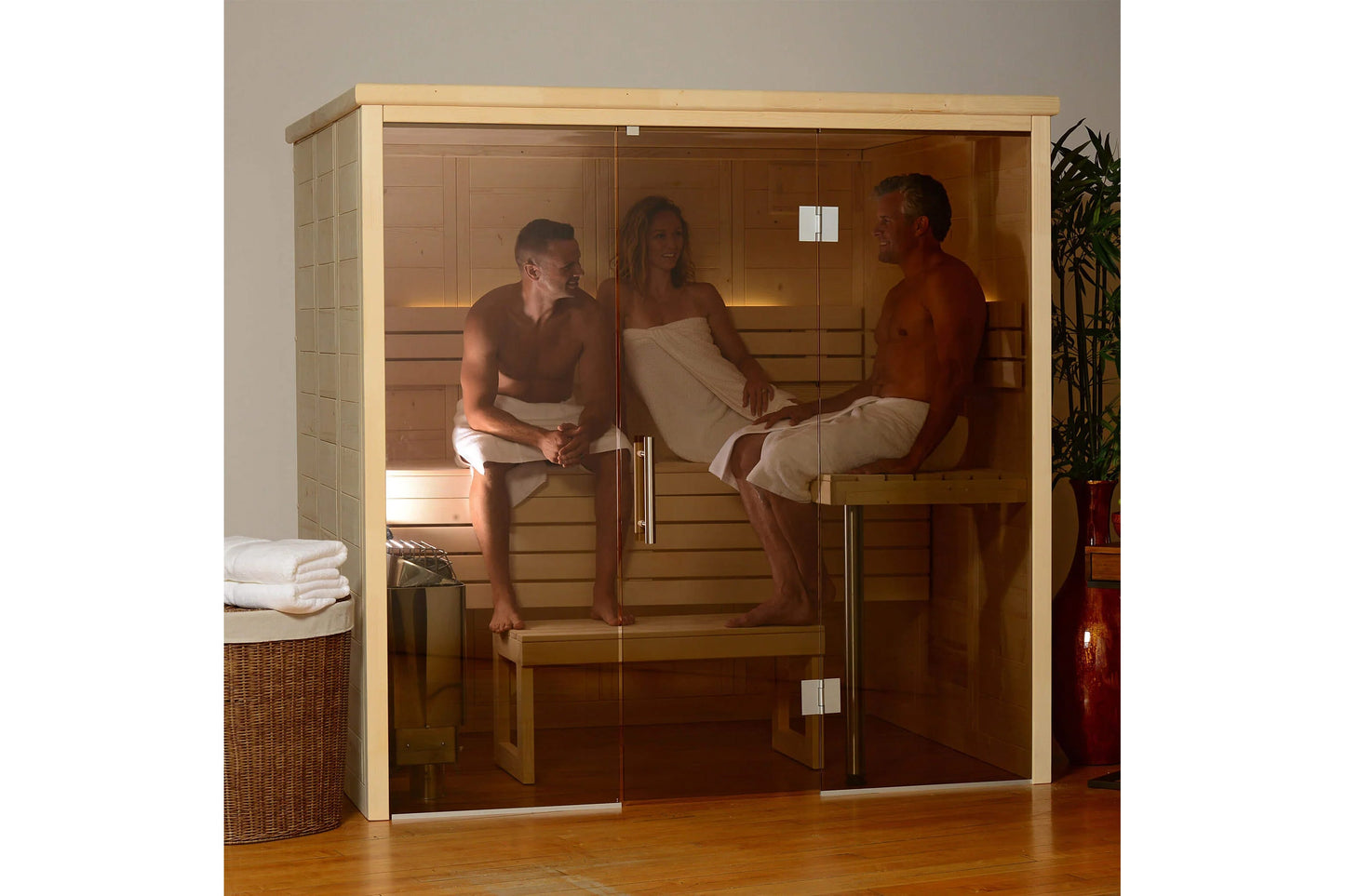 Almost Heaven Worthington indoor sauna with light wood frame, glass doors, and interior cedar benches, three people inside de