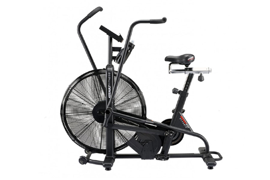 Black stationary exercise bike with oversized fan wheel, dual handlebars, and padded seat on white background