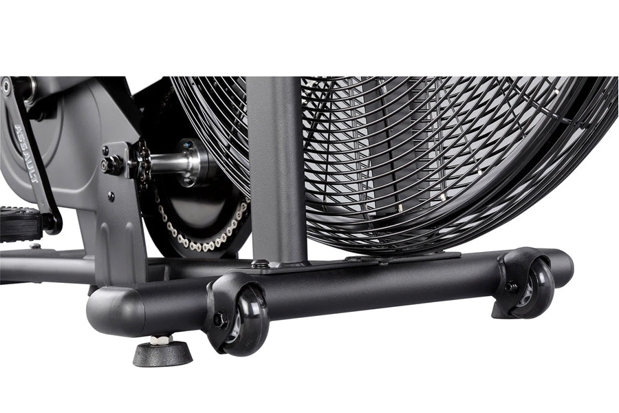 Close-up of black metal base with wheels and casters supporting industrial-style stationary air bike fan on white background