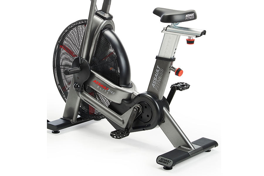 Assault Fitness Elite air bike with black mesh fan wheel, gray steel frame, black seat, and digital display on white backgrou