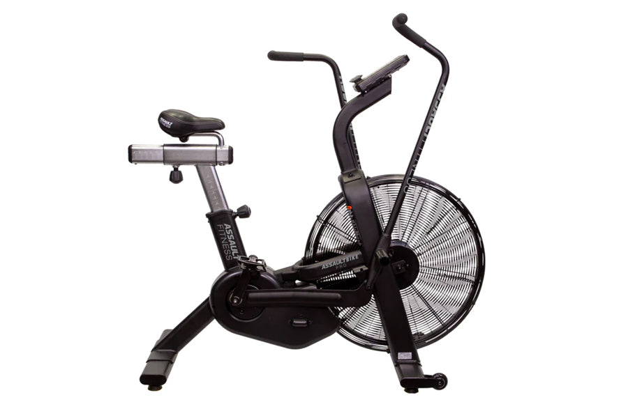 Black stationary air bike with large fan wheel, curved handlebars, and padded seat on white background