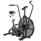 Black stationary air bike with large fan wheel, padded seat, dual handles, and foot pedals on white background