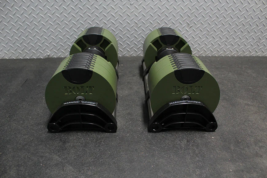 Pair of olive green and black adjustable dumbbells with metal grip bands, displayed front-facing on gray floor mat