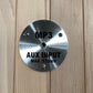 Brushed silver metal control panel with MP3 and AUX INPUT MAX 175mV text, mounted on light wood background