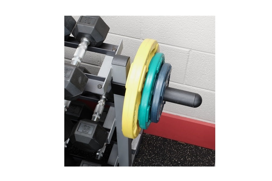 Barbell with yellow, teal, and dark blue weight plates loaded on black steel rack in gym setting