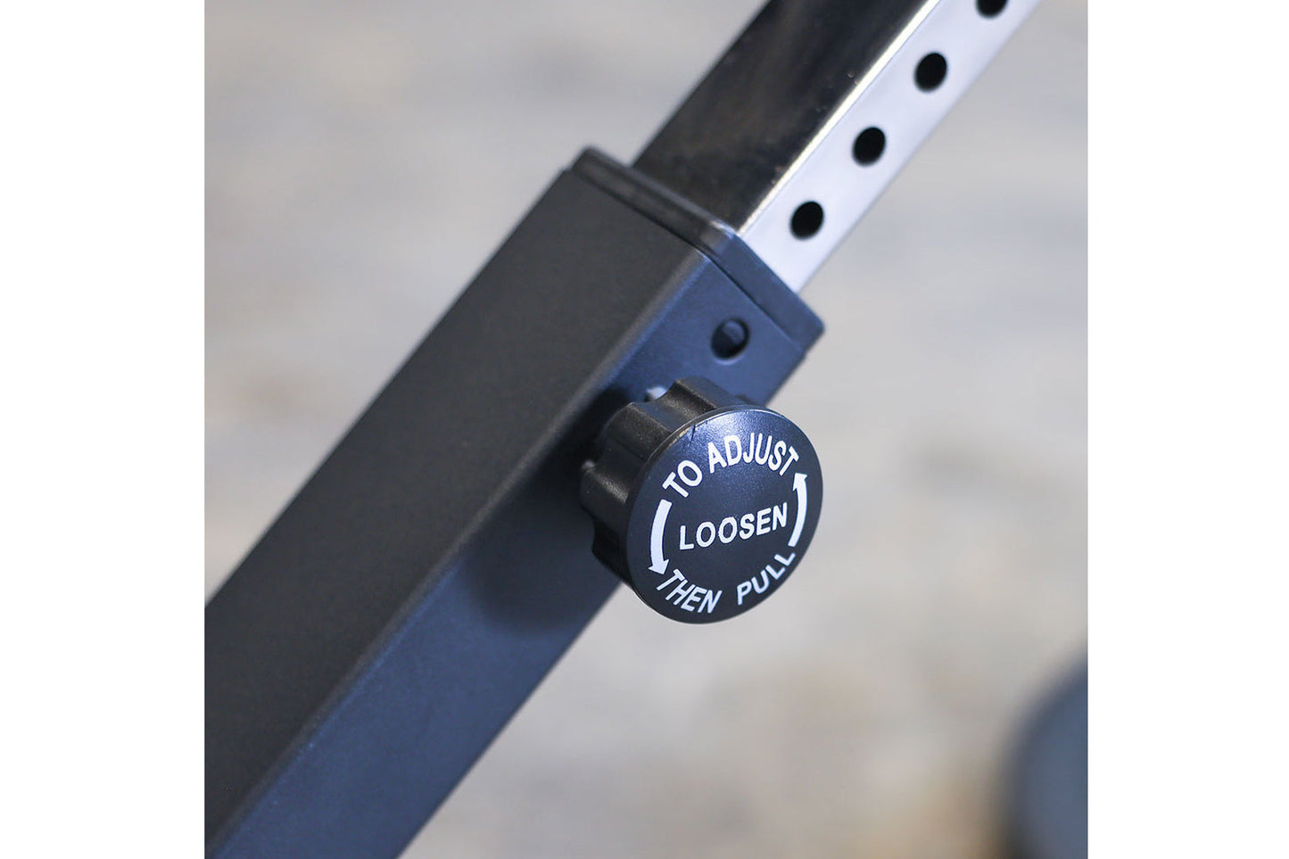 Blue and black adjustable ab/back hyperextension machine with adjustment knob labeled "to adjust loosen then pull