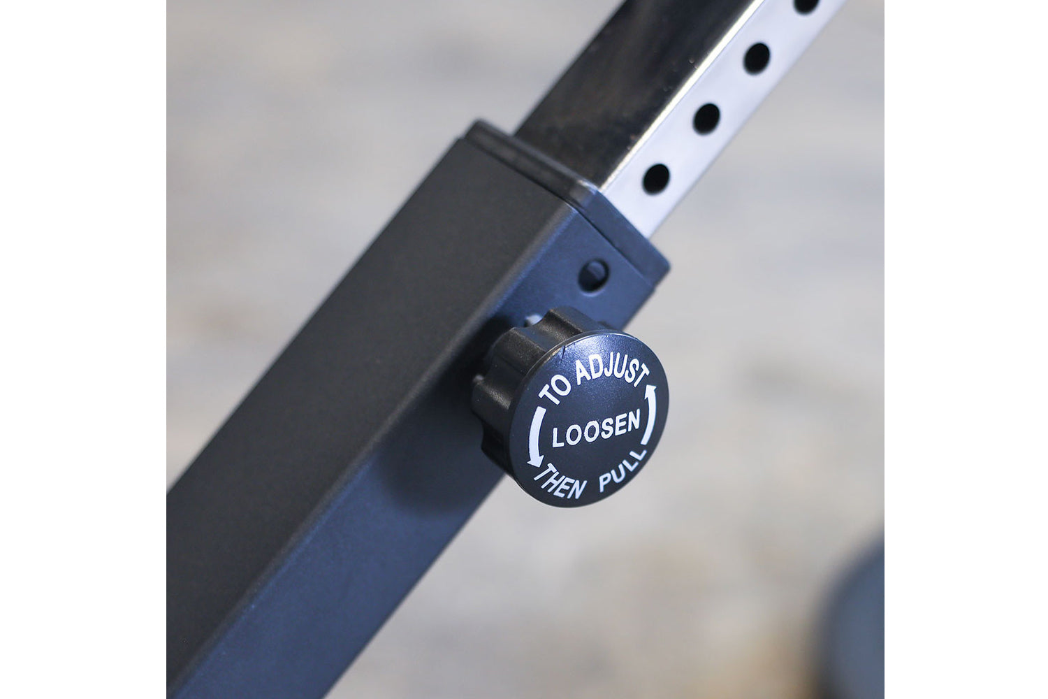 Blue and black adjustable ab/back hyperextension machine with adjustment knob labeled "to adjust loosen then pull