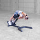 Woman in blue and white athletic wear performing ab exercise on black hyperextension bench in concrete garage setting