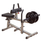 Body-Solid commercial seated calf raise machine with black padded seat, gray steel frame, curved foot plate, and black weight