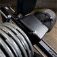 Body-Solid leg press machine with black metal frame, padded seat, and loaded weight plates in home gym setting