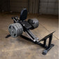Black leg press machine with padded seat and backrest, dual metal weight plate holders, on concrete gym floor