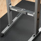 Gray and black dip station with textured diamond plate platform, metal frame, and grip handles on black mat floor