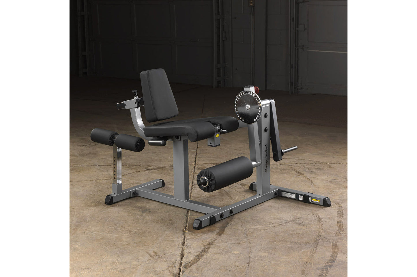Body-Solid leg extension and curl machine with gray steel frame, black padded seat and leg pads, adjustable weight plate sele