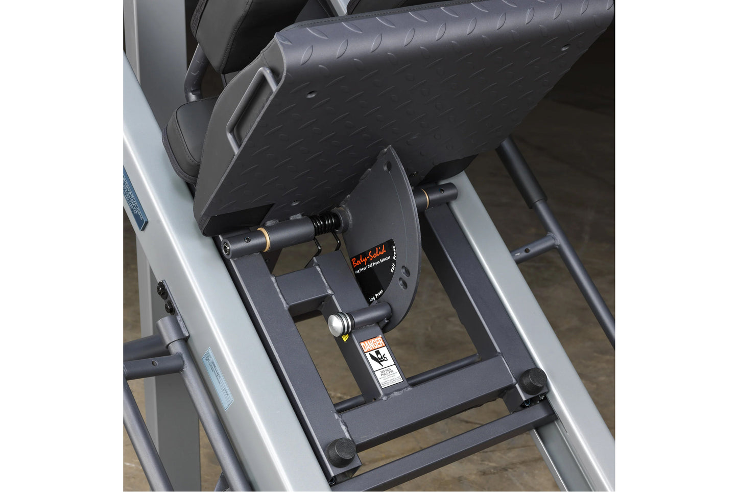 Body-Solid leg press and hack squat machine with black textured footplate, silver frame, and adjustment handles, overhead vie