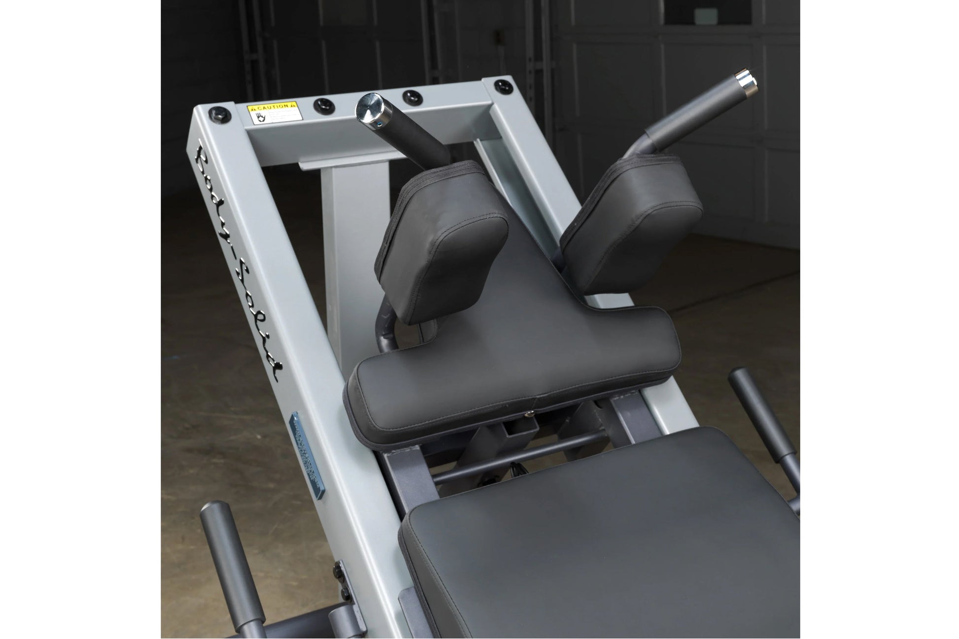 White and gray leg press machine with black padded seat and footrest, adjustable handles, flat lay view