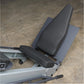 Black padded seat with blue textured footplate on silver Body-Solid leg press machine, viewed from above on concrete floor