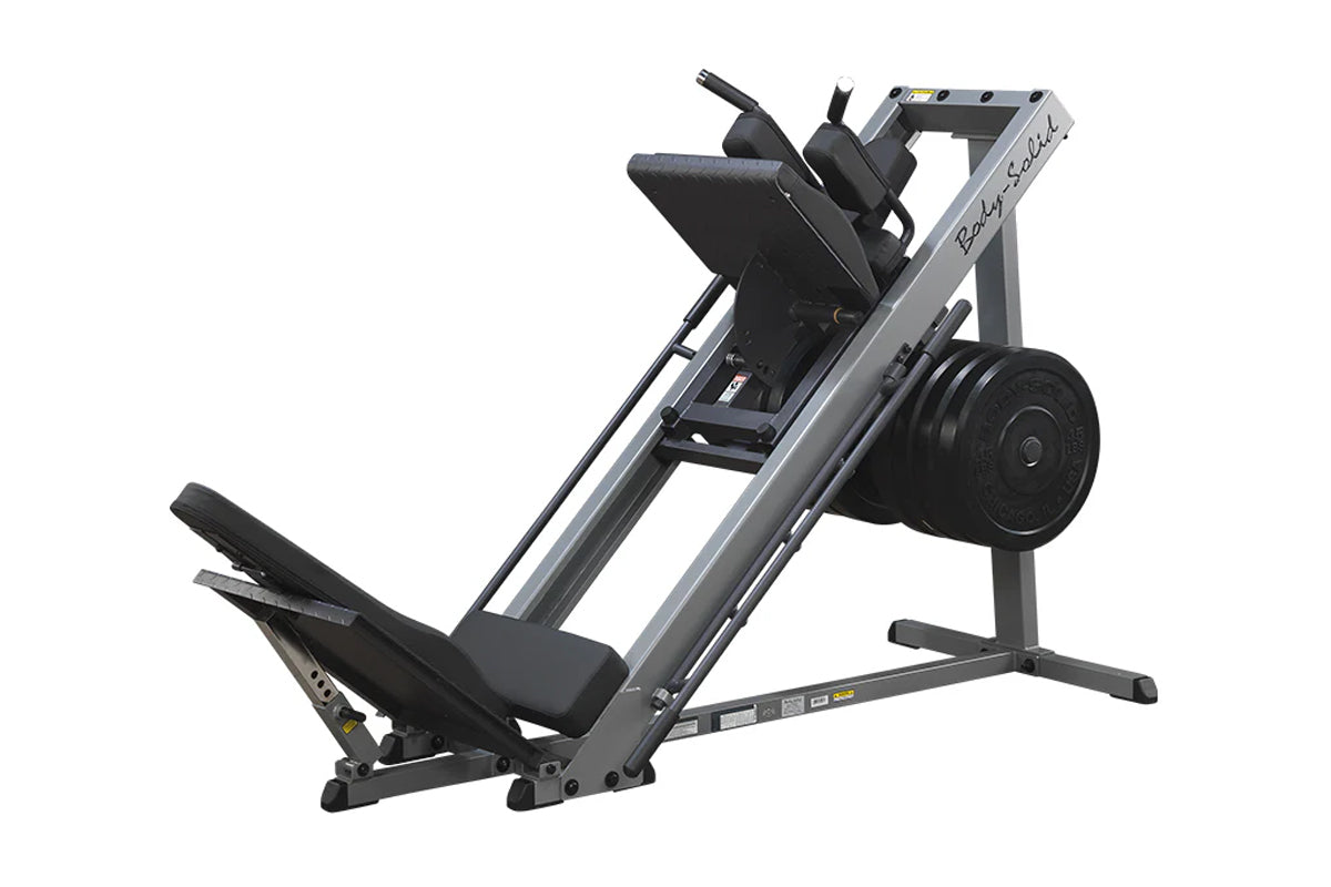 Body-Solid leg press and hack squat machine with gray frame, black padded seat and backrest, weight plate storage, on white b
