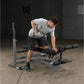 Man using gray Body-Solid PowerCenter Combo Bench with leg extension attachment in gym setting