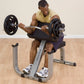Man performing bicep curl on gray and black preacher curl bench with black weight plates and barbell, wearing yellow tank top