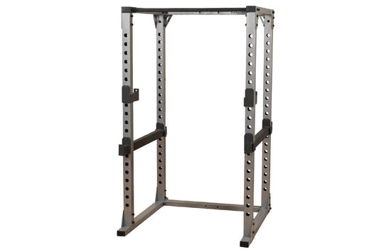 Body-Solid Pro Power Rack with gray and black steel frame, adjustable safety bars, and perforated upright posts on white back