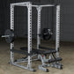 White and black power squat rack with barbell and weight plates in garage setting